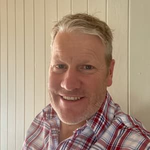 Smiling man in checked shirt indoors